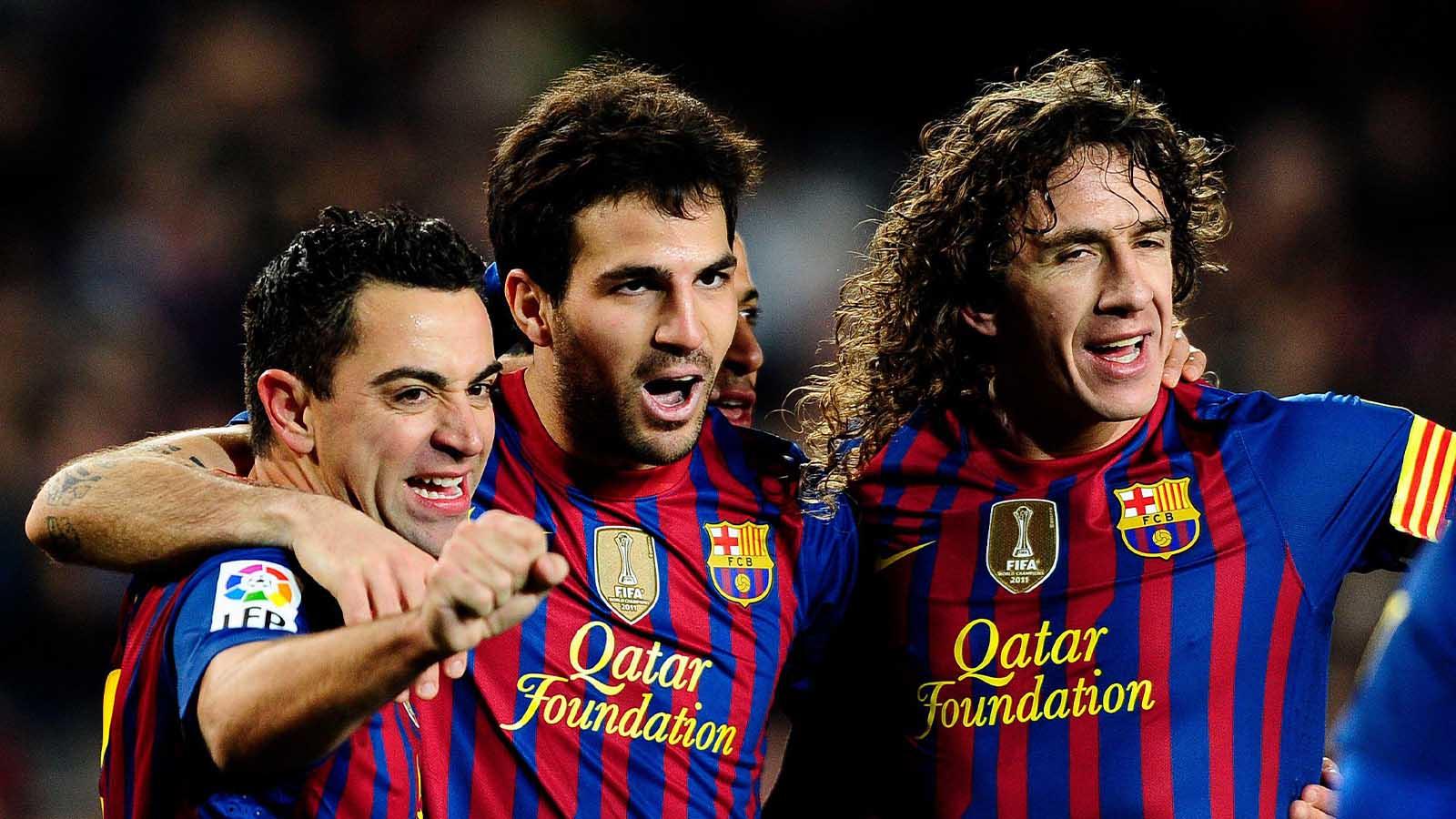 Xavi Hernandez. Cesc and Carles Puyol celebrate together.