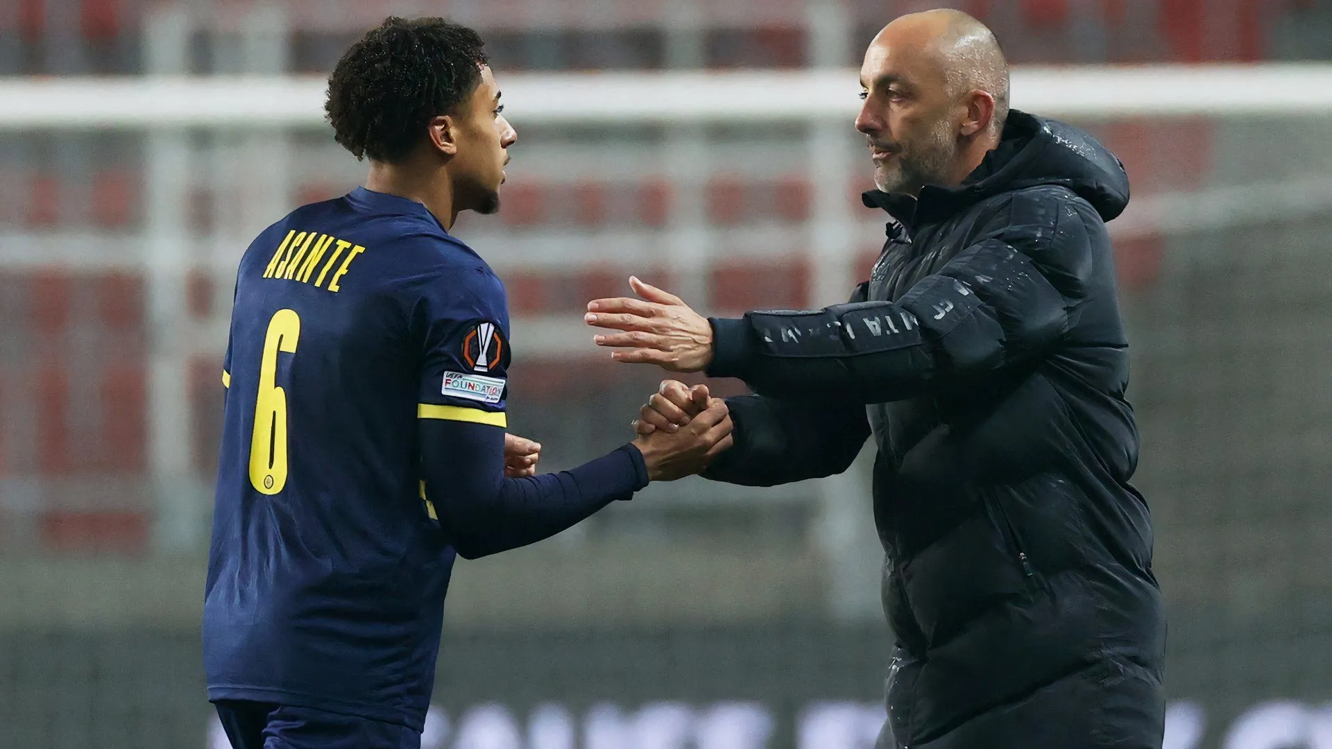 HLV Zarko Lazetic và Tyrese Asante trong trang phục Maccabi Tel Aviv, biểu tượng của sự hợp tác và tài năng trẻ trên sân cỏ Israel.
