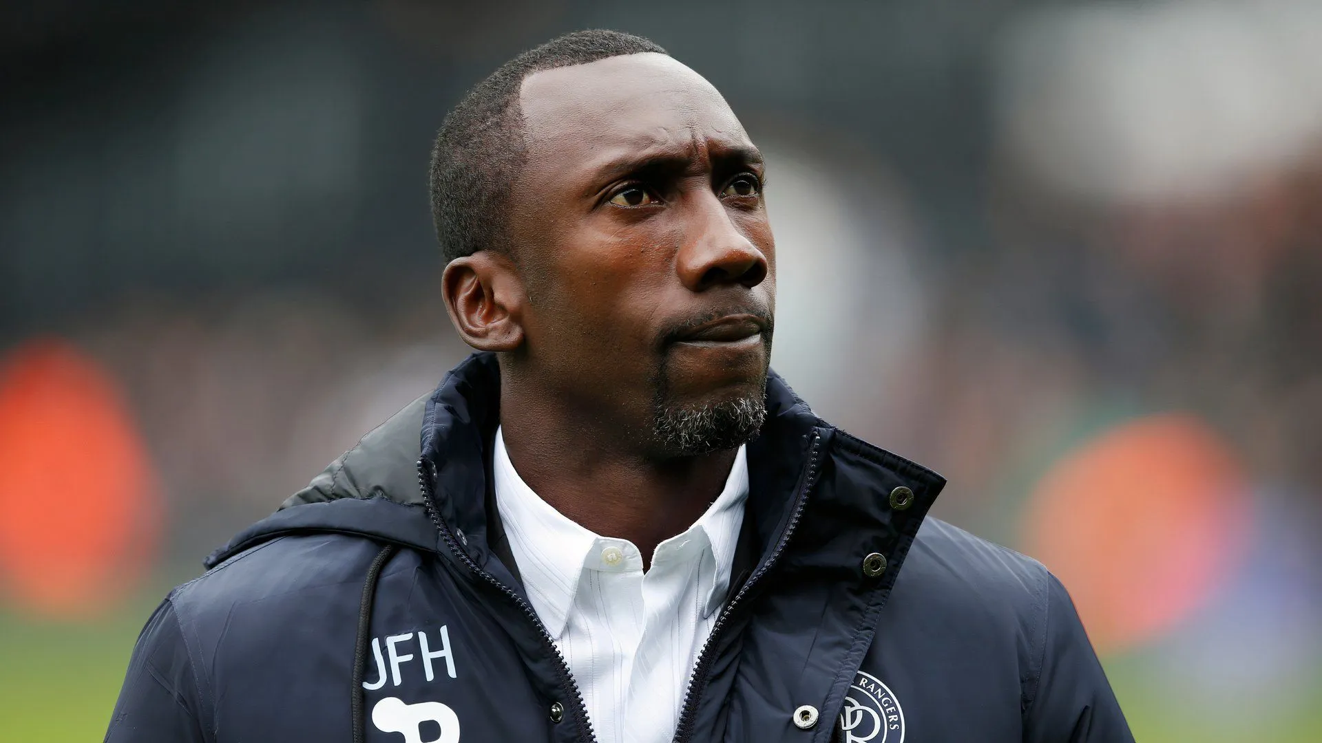 Huấn luyện viên Jimmy Floyd Hasselbaink đứng trên sân tập QPR, dáng vẻ trầm tư